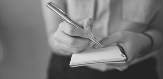 close-up-of-journalist-holding-a-notebook-770